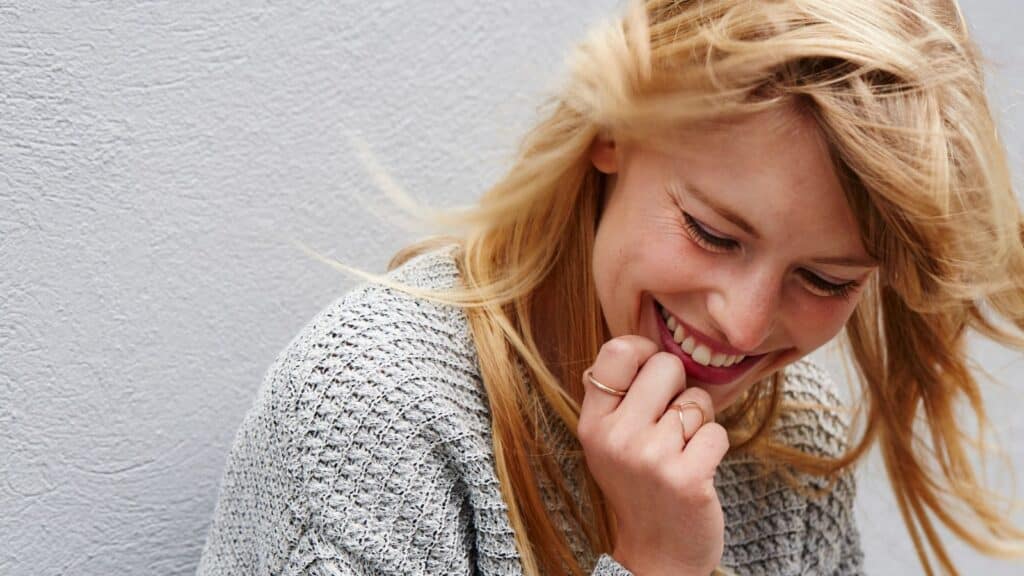 Blonde woman leaning over laughing