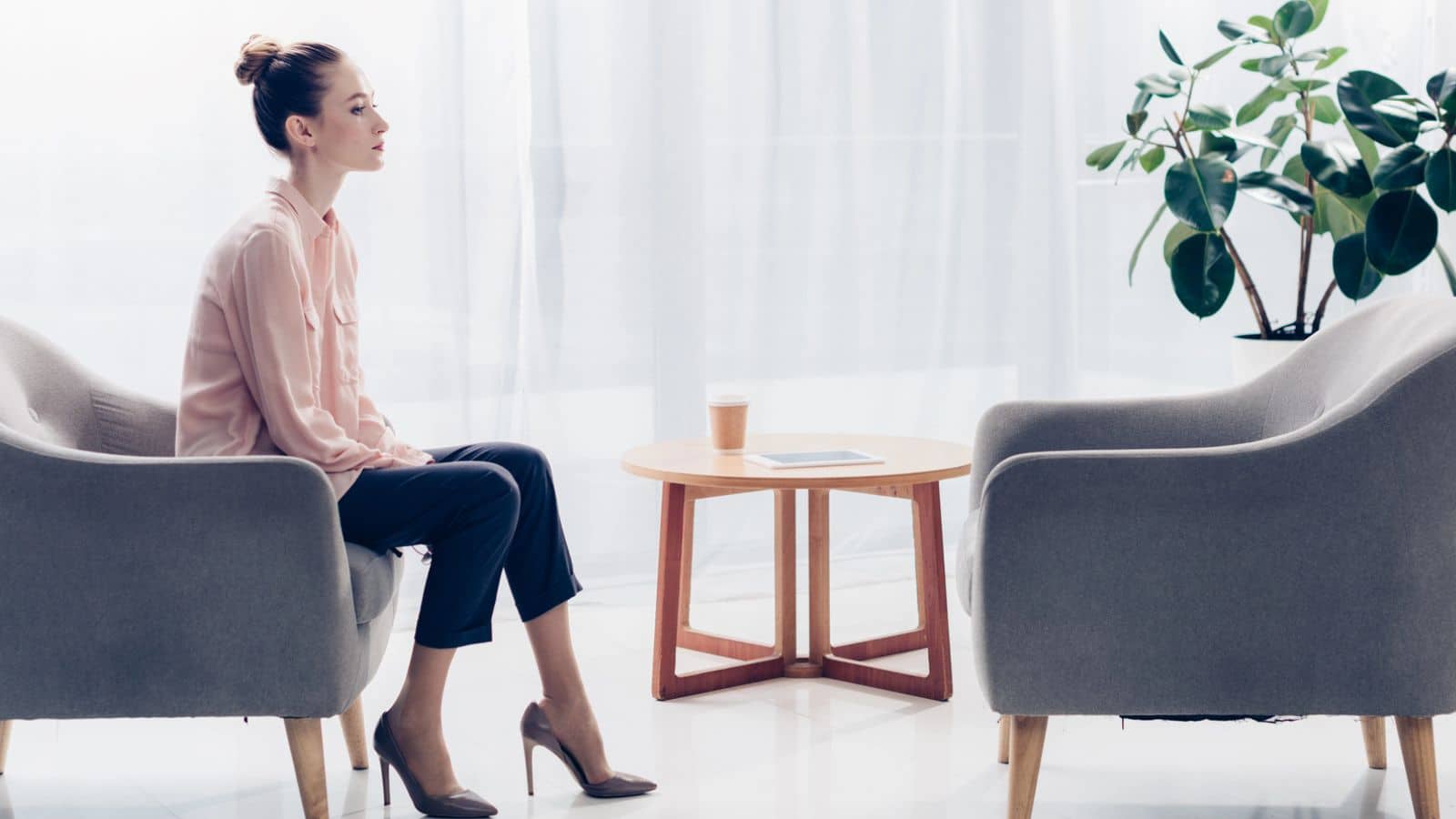 Woman sitting alone in a minimalist room