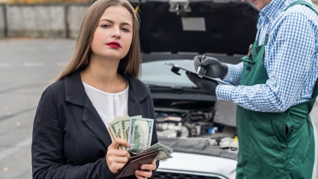 Woman holding cash to pay for car repairs