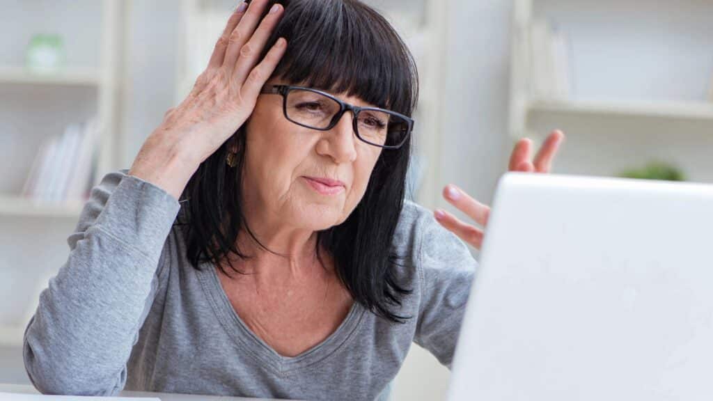 Senior woman looking frustrated working on her laptop