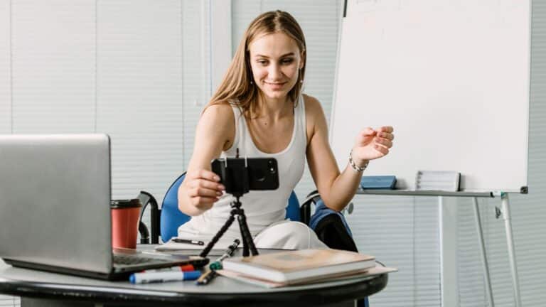 Young woman filming herself with her phone
