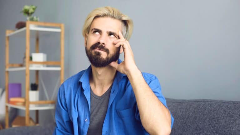 Man holding his hand to his face looking perplexed
