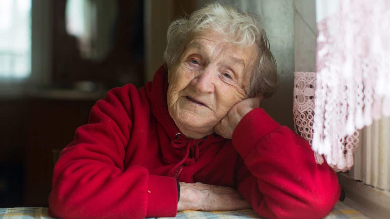 Old woman sitting with her head on her hand