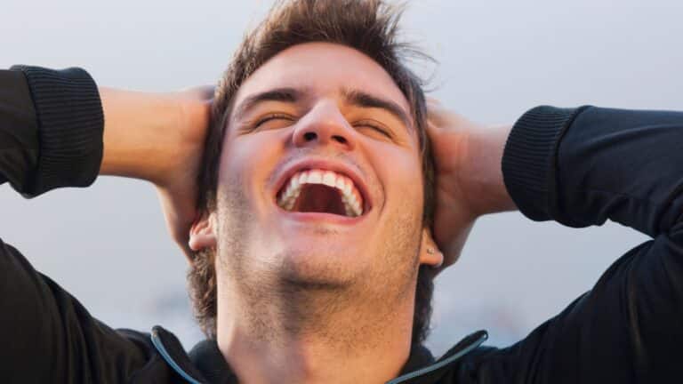 Closeup of man with hands on his head and smiling