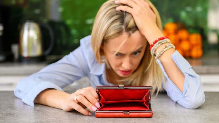 Woman looking distraught over her empty wallet