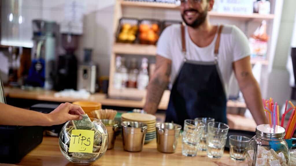Person putting money into a tip jar