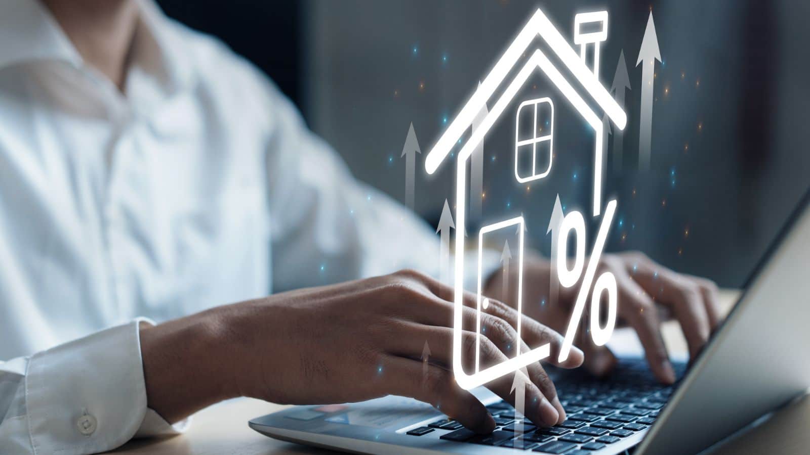 Man working on his laptop with a hologram of a house