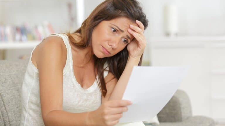 Woman looking at a paper looking concerned