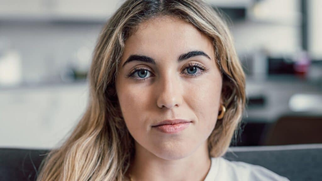Closeup of young blond woman smirking