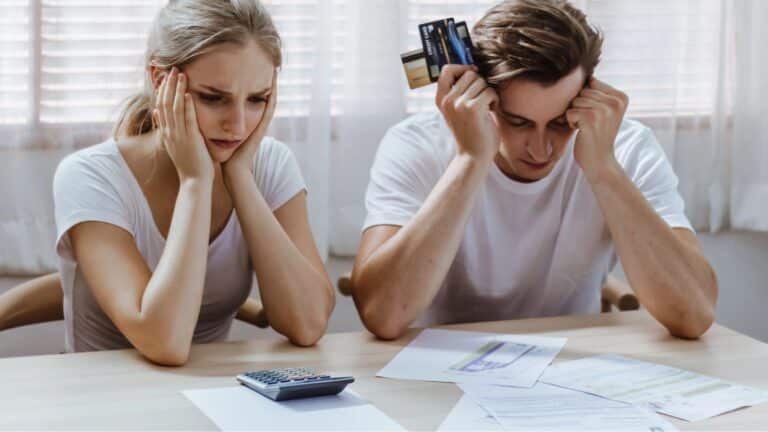 Couple looking upset while paying bills