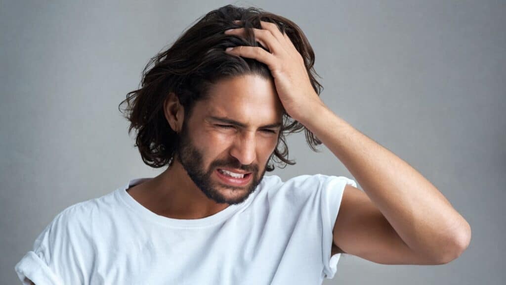 Man holding his forehead and looking regretful