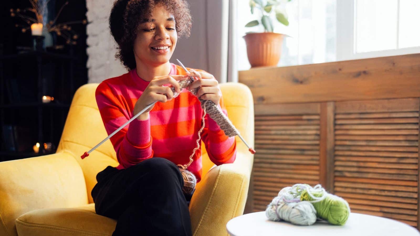 Young woman sitting and knitting