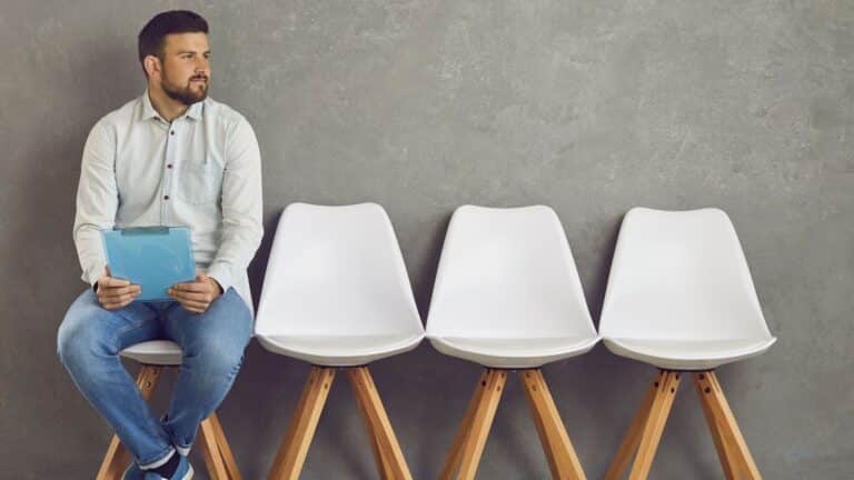 Man sitting in a row of chairs waiting to be interviewed