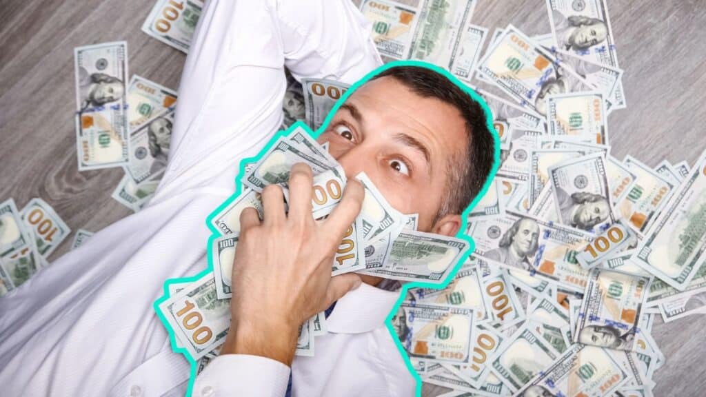 Wealthy man laying on the ground covered in money