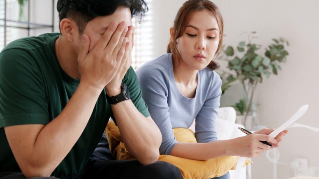 Young middle class couple paying bills and looking stressed