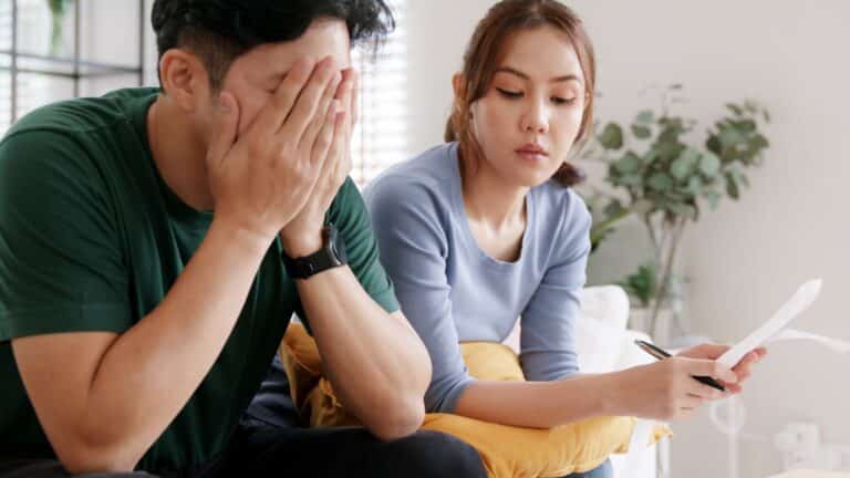 Young middle class couple paying bills and looking stressed
