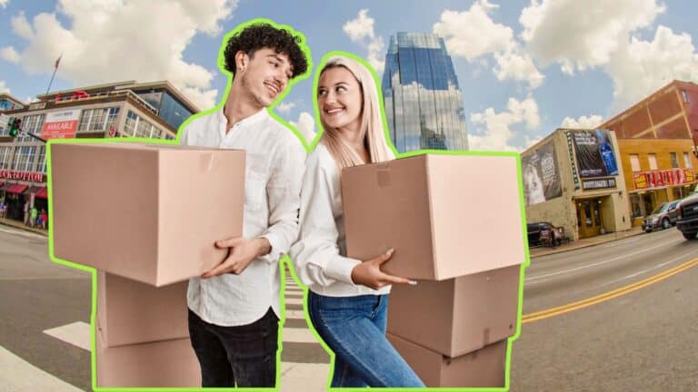Wide shot of downtown Nashville, TN with couple holding moving boxes