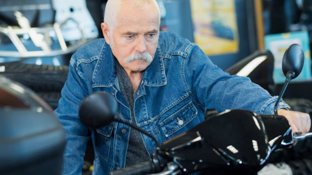 Old man looking grumpy sitting on a motorcycle