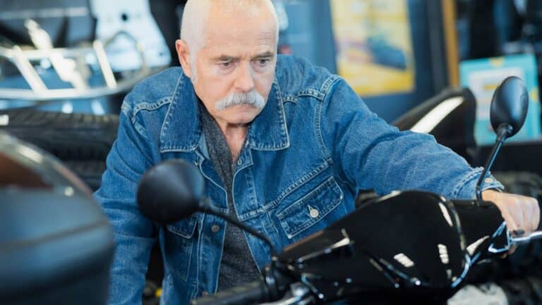 Old man looking grumpy sitting on a motorcycle