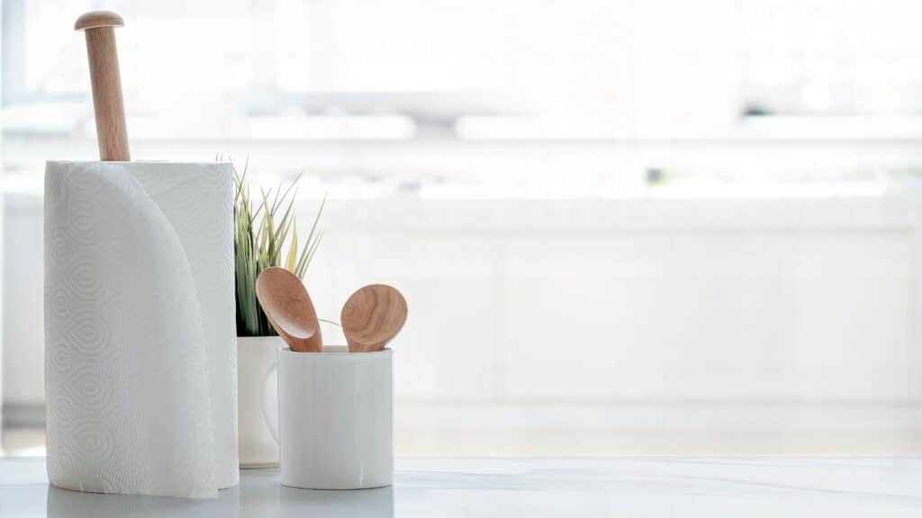 Paper towels and utensils sitting on a kitchen counter