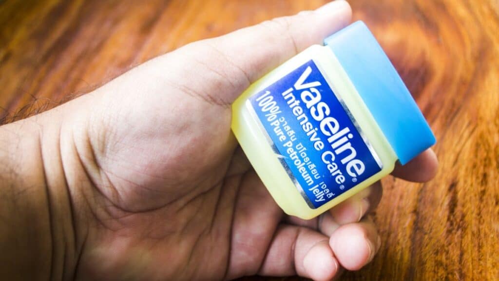 Person holding a container of Vaseline