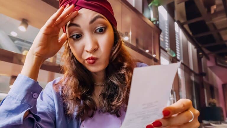 Woman looking at a receipt with a frustrated look on her face