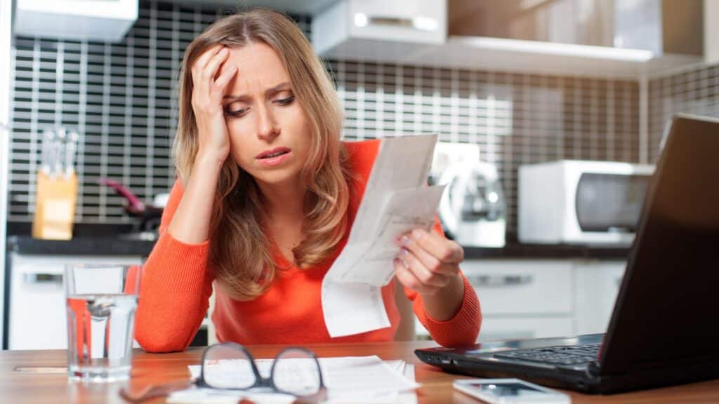 Woman looking at a receipt with a stressed look on her face