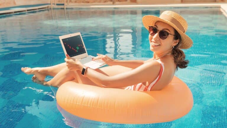 Woman floating in her pool while working on her tablet