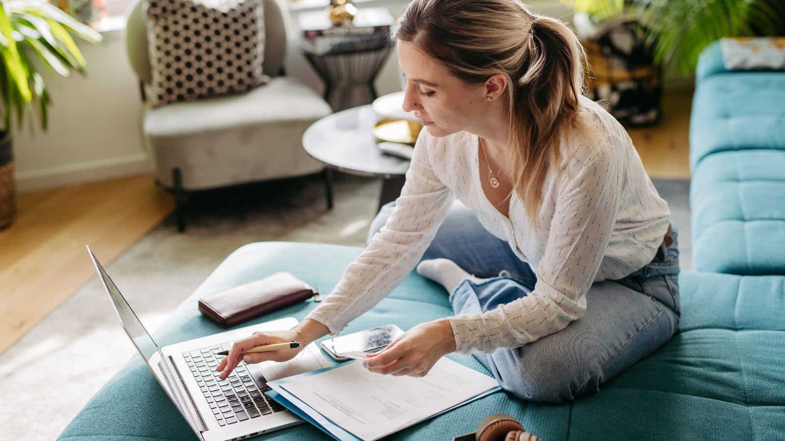 Woman paying bills on her couch
