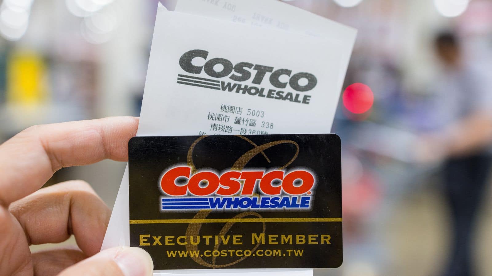 Person holding their Costco membership card and receipt