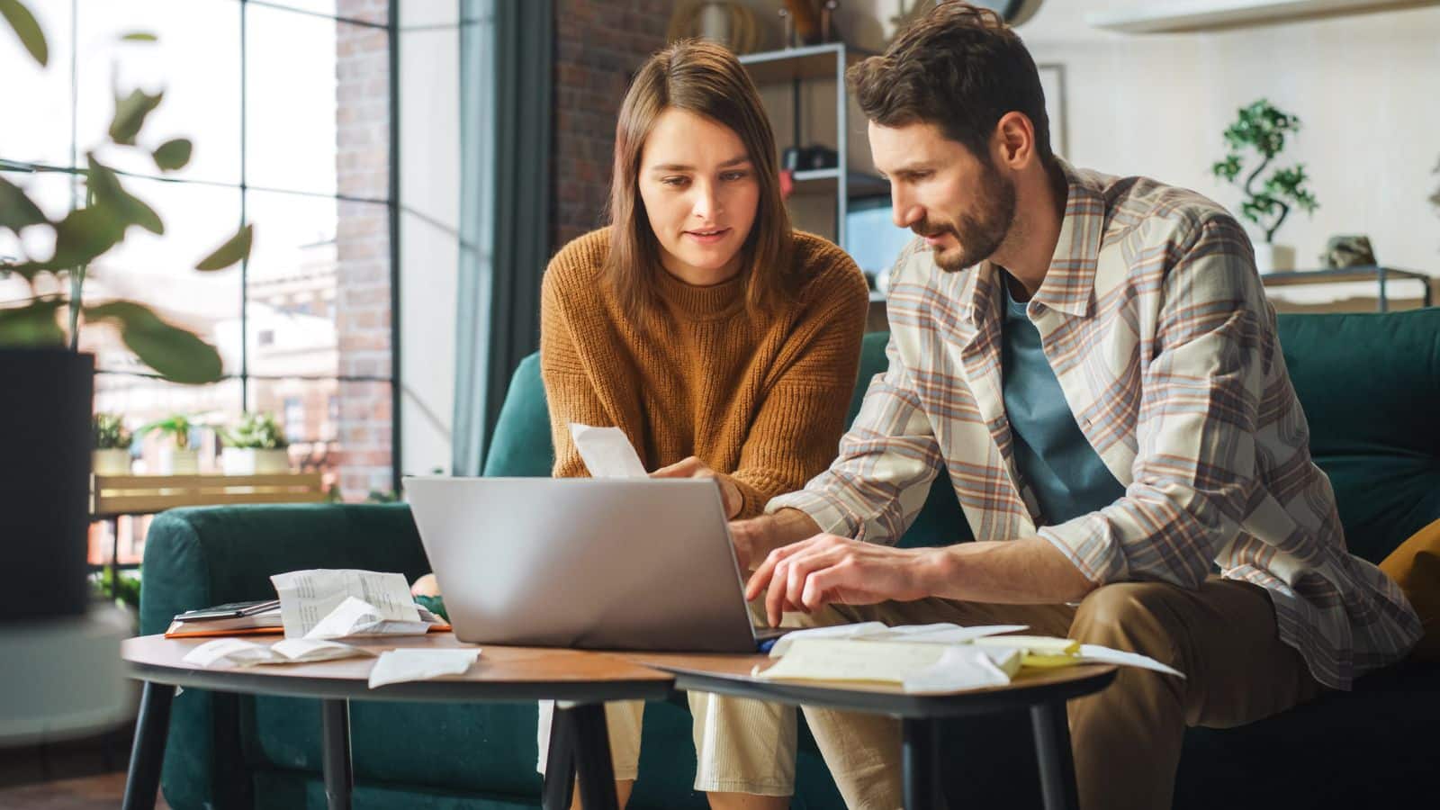 Couple sitting on couch working on their budget