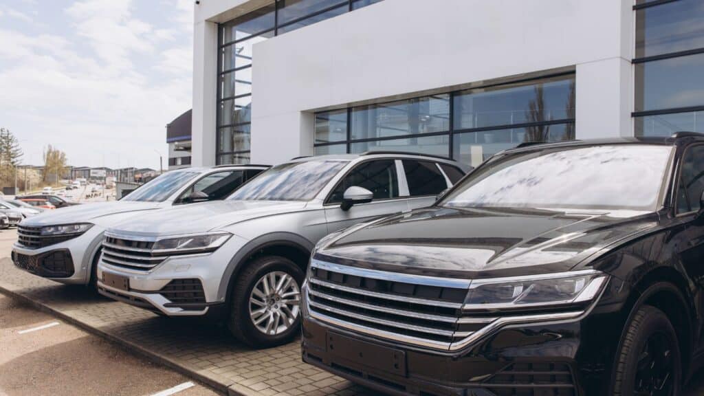 Luxury SUVs parked out front of a car dealership