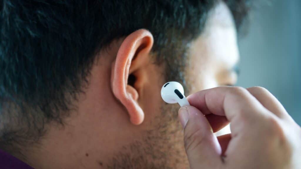 Man putting an AirPod in his ear