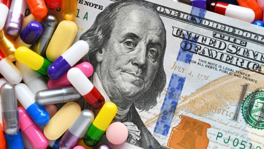 Cash with pills laying on top of it