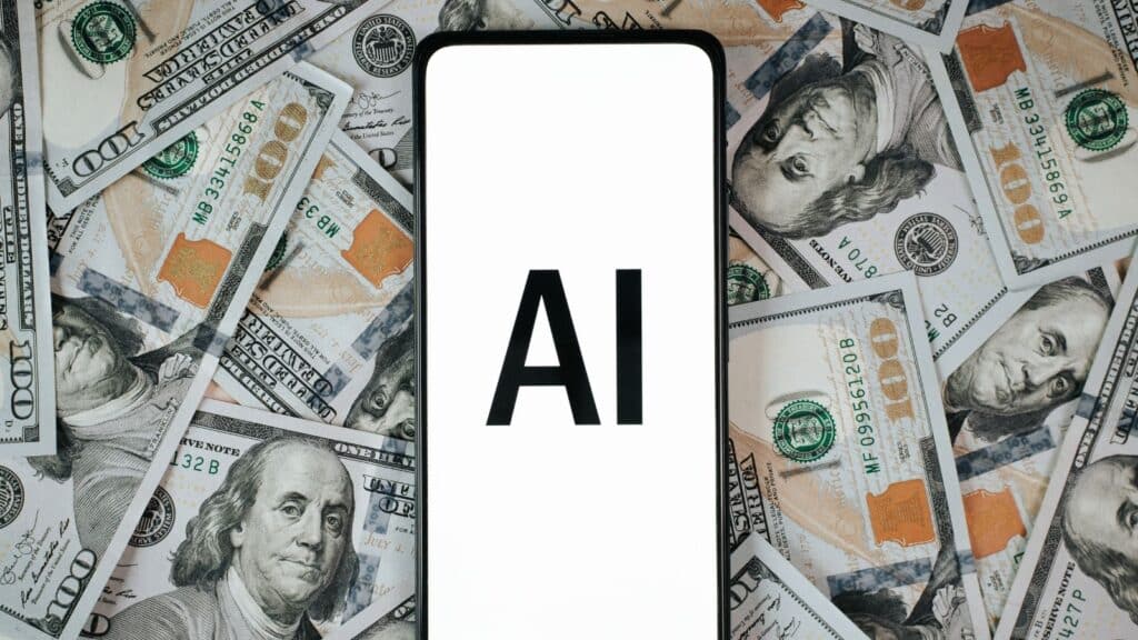 Cell phone with the letters AI on the screen with a background of cash