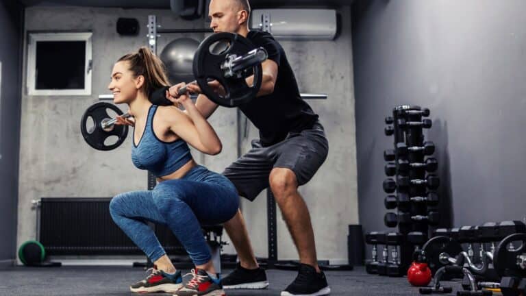 Personal trainer training a female customer in the gym