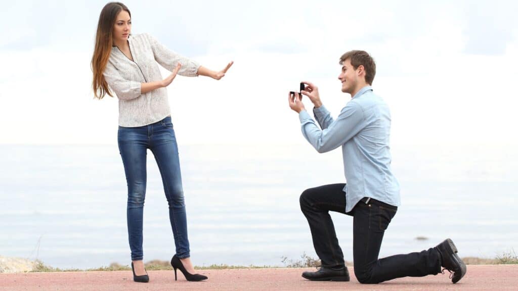 Woman rejecting proposal by man down on his knee