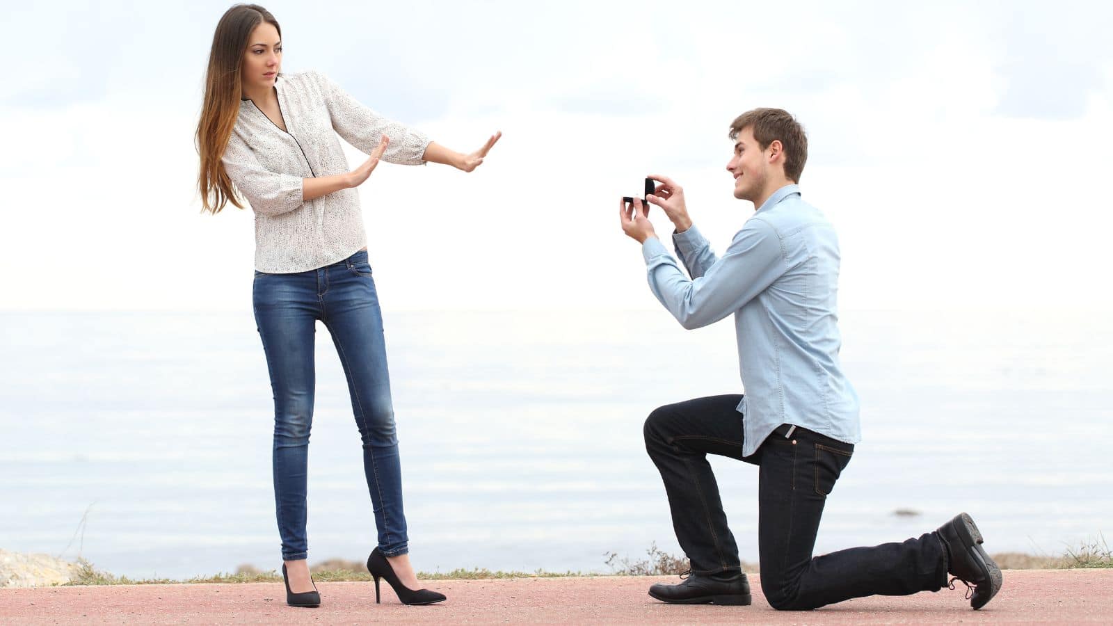 Woman rejecting proposal by man down on his knee