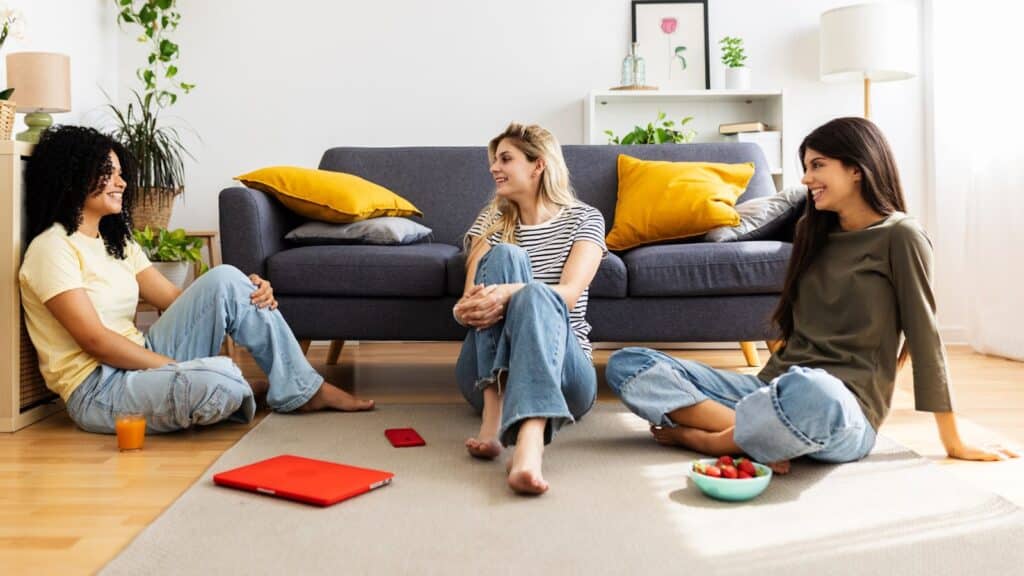 Three female roomates sitting on the floor talking