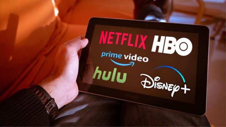 Man holding a tablet with streaming services on the screen