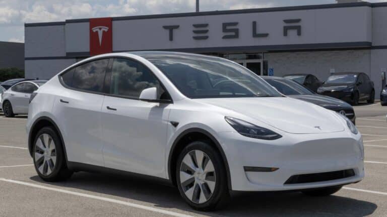 White Tesla Model Y sitting outside of a Tesla dealership