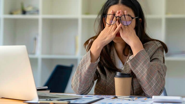 Young woman looking stressed at her desk