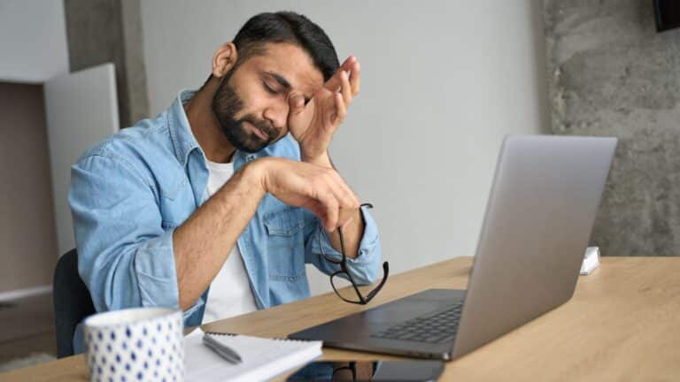 Man sitting at his desk looking very stressed out