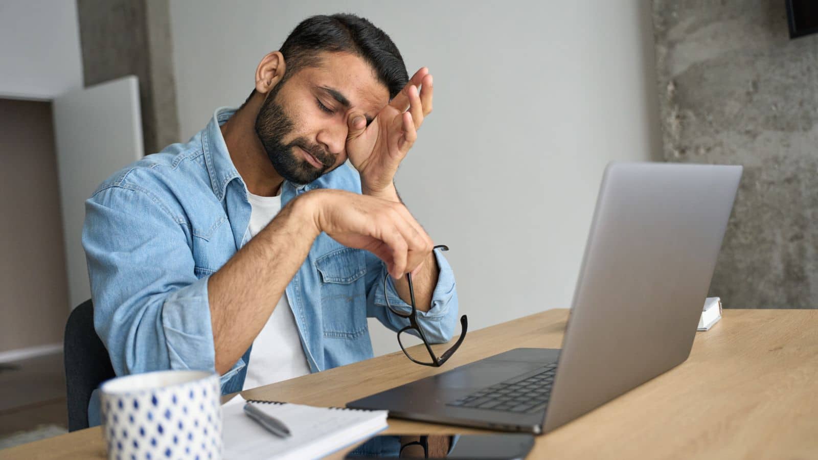 Man sitting at his desk looking very stressed out