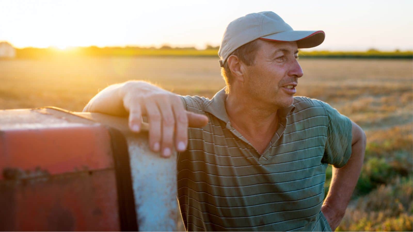 Famer in the field leaning on his tractor