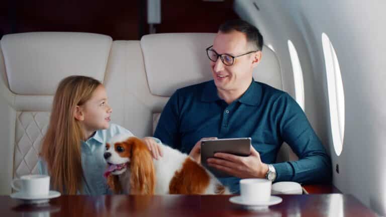 Father and daughter riding on private plane with their dog