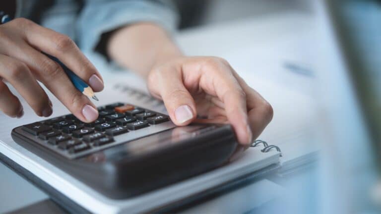 Woman using a calculator to pay her bills