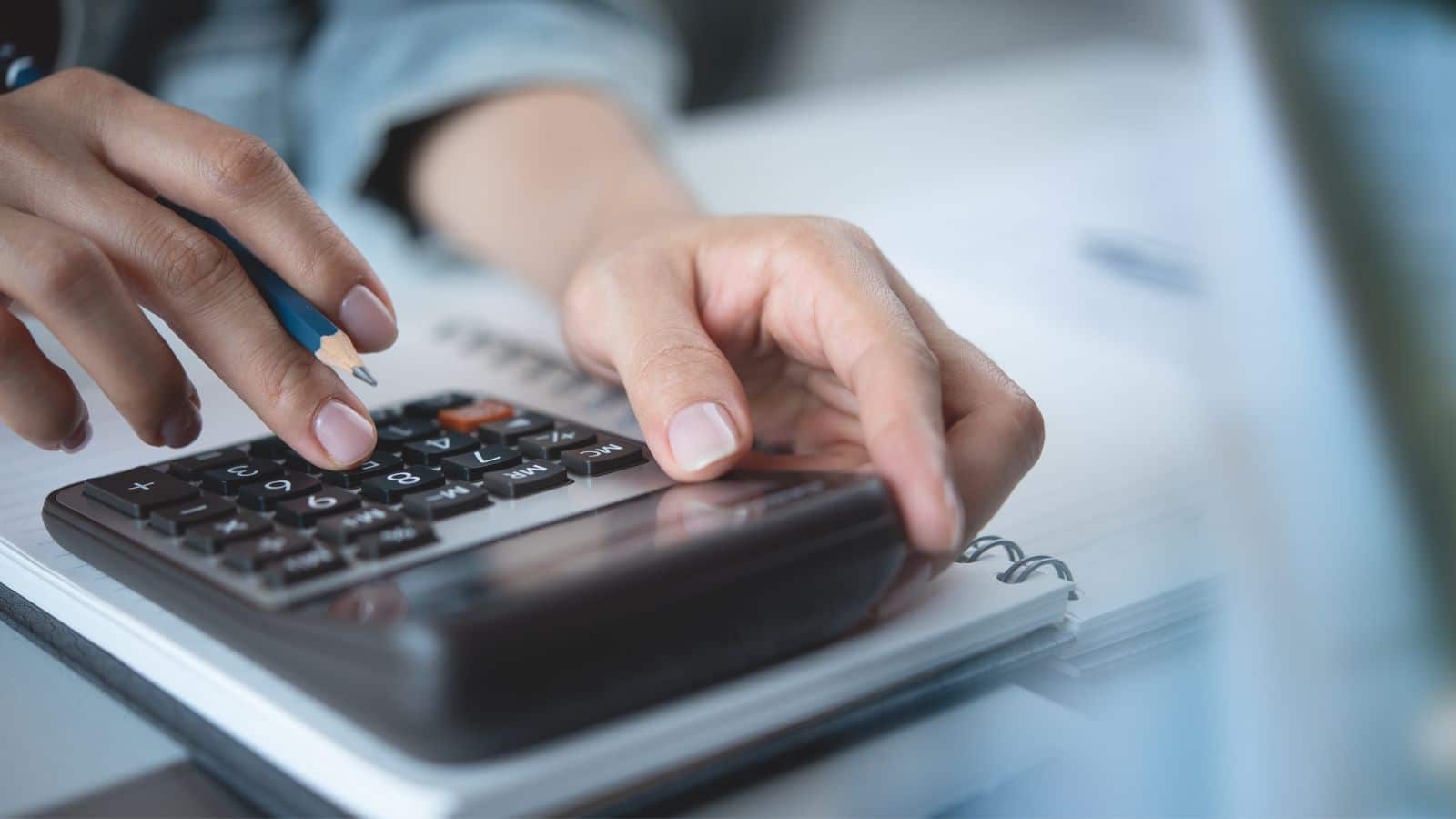 Woman using a calculator to pay her bills
