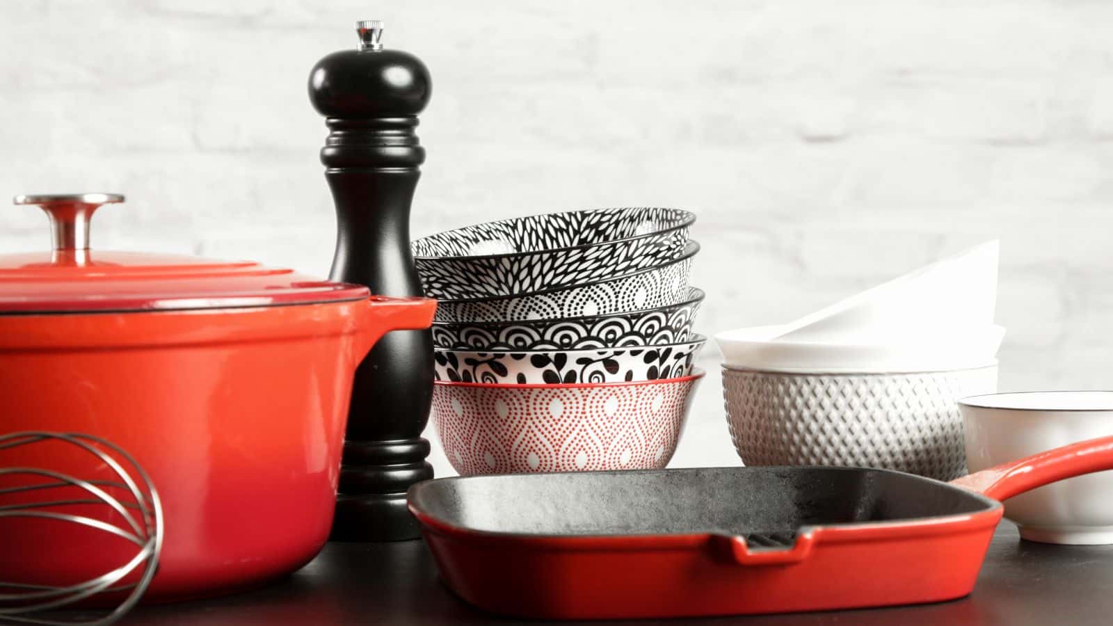 Red, black and white mismatched cookwear on a counter
