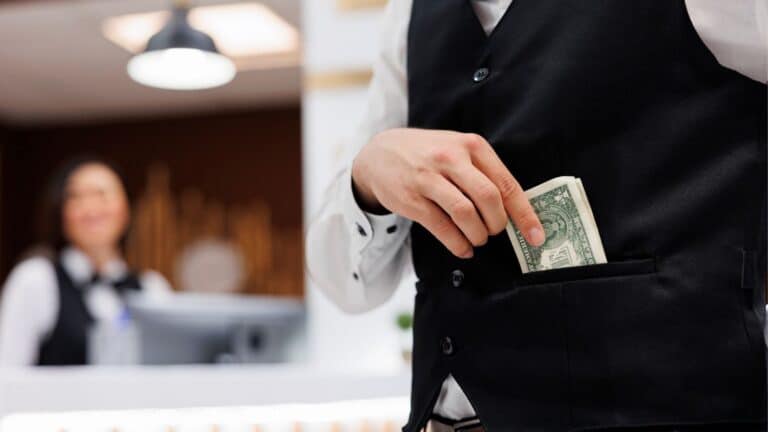 Hotel worker putting a tip in his suit pocket